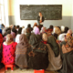 Image: From the back, girls sit in a crowded classroom in Afghanistan with the teacher in front of them